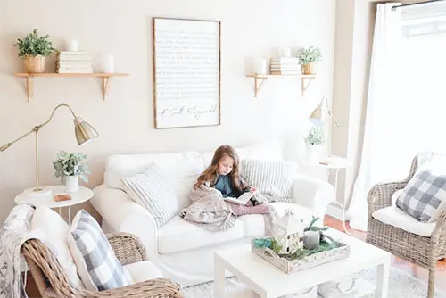 Little girl reading on a sofa in a bright room