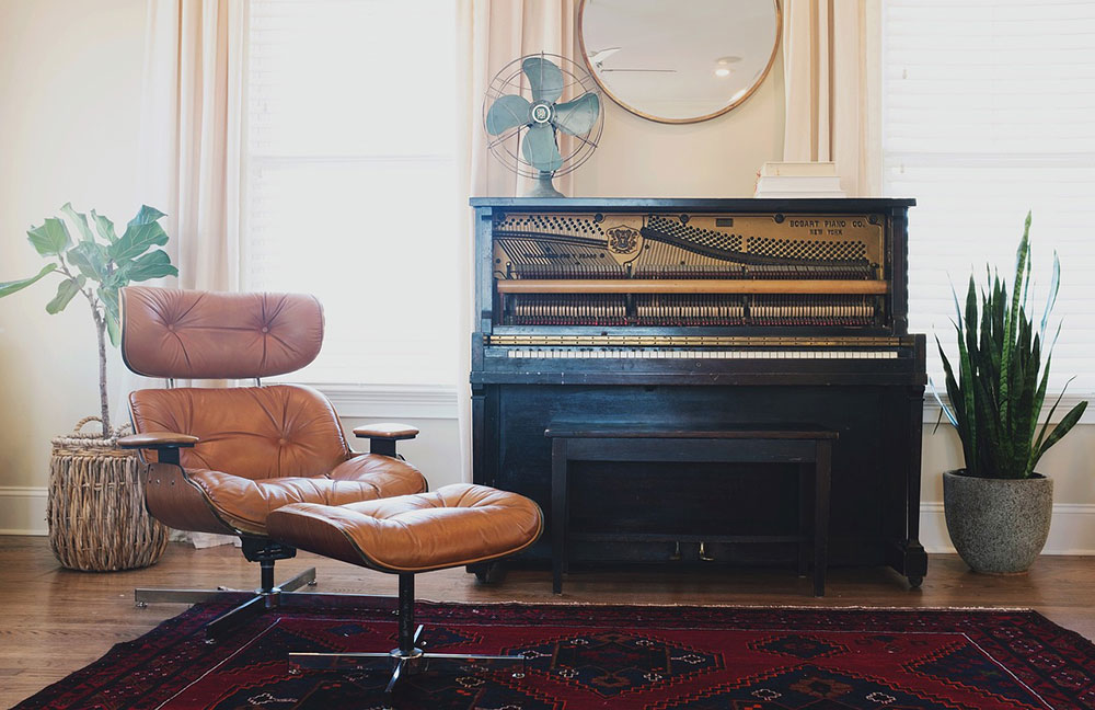 Piano and lounger in a simple room to emphasise the importance of not trying to focus the eye on too much in a room